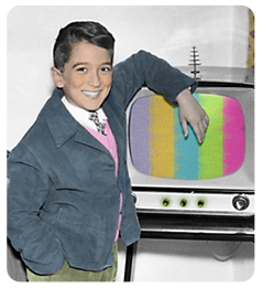 Smiling boy standing in front of television